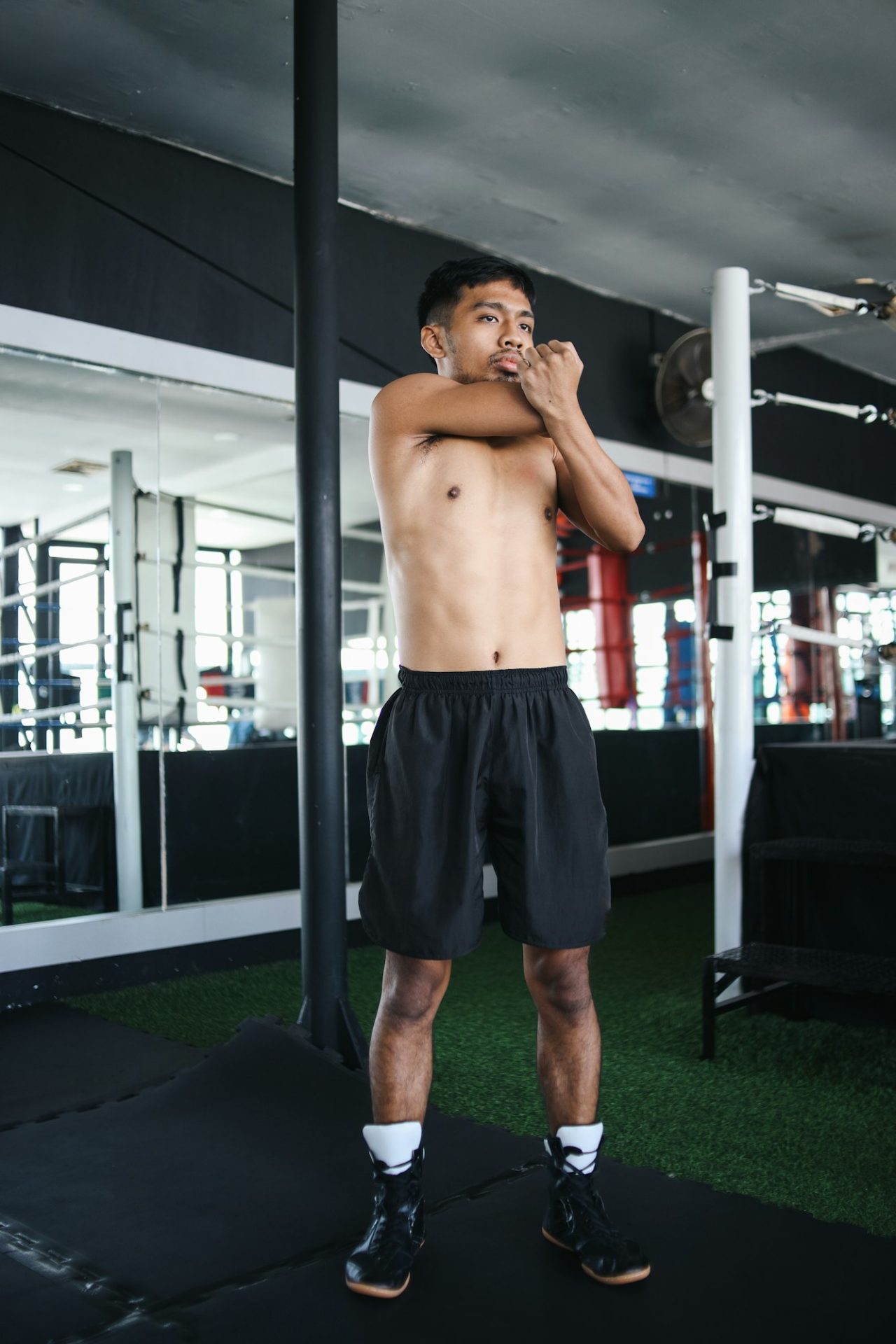 Confident Young Asian Man Stretching Elbow At MMA